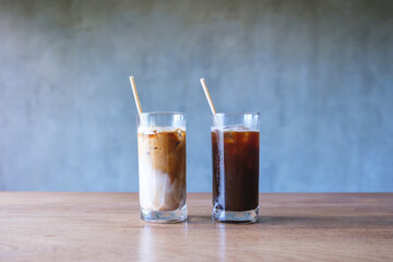 Two glasses of iced coffee with bio drinking straws on wooden table