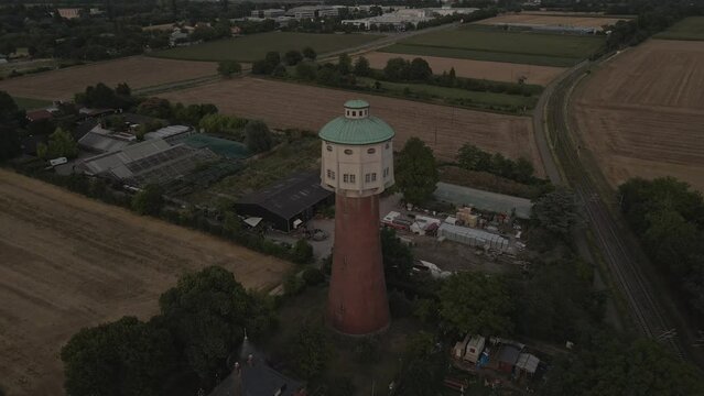 Late Evening Drone pullback shot from the ladenburg Water tower in Germany showing the surrounding fields and Rail track 