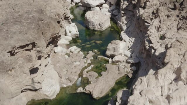 Drone top-down shot of disappearing river waters in a rocky riverbed on Socotra Island. Yemen. 