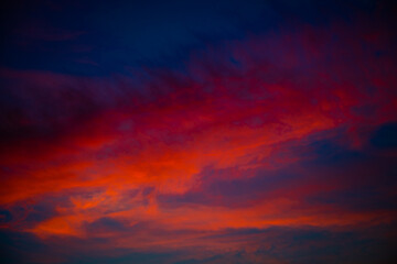 Beautiful red clouds in the dark blue sky, summer sunset