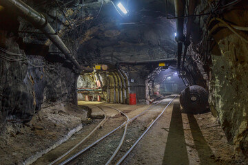 Dark tunnel of kimberlite mine with railroad.