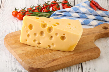 Maasdam cheese piece over board