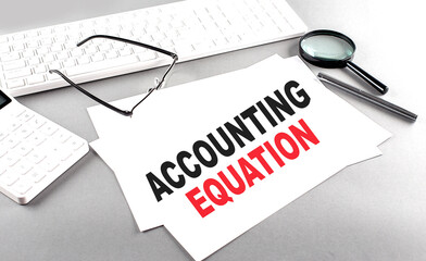 ACCOUNTING EQUATION text on a paper with keyboard, calculator on grey background
