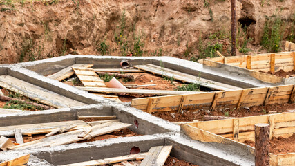 Dismantling the strip foundation formwork at the construction site. Dismantling of wooden formwork panels after concrete hardening. Foundation works.