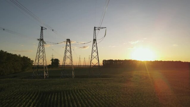 Wide slider shot of High voltage power lines at sunset. Aerial view