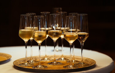 Glamour party. A lot of champagne Prosecco glasses on a golden plate to welcome the guests of a party.