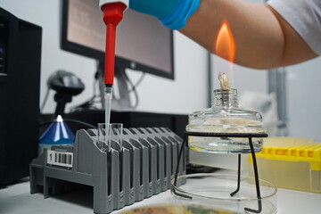 Almaty, Kazakhstan - 08.15.2022 : The laboratory assistant pours the liquid into the flask with a dispenser.