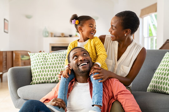 Little black girl playing with parents at home