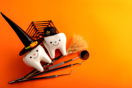 dental concept. figurines of teeth in halloween costumes and dental instruments. pumpkins and broom