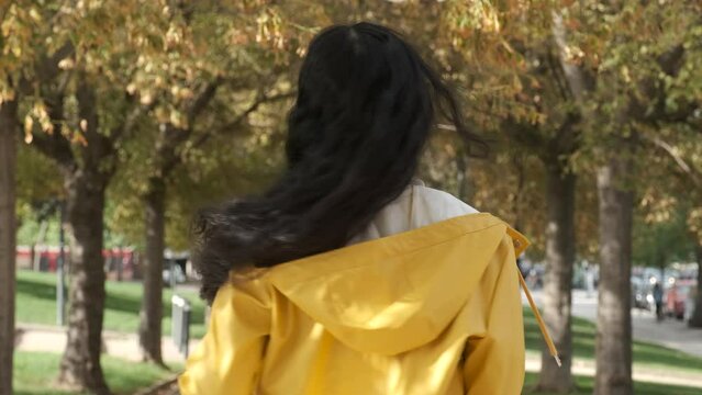 Young latin girl dancing bachata dressed in yellow raincoat at street in autumn.