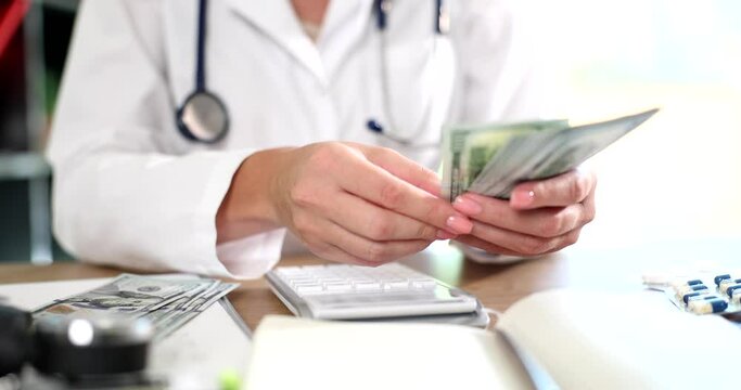 Doctor counting money with calculator in clinic 4k movie slow motion