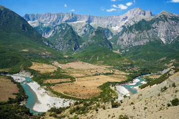 Fototapeta na wymiar breathtaking and untouched scenery of Albanian mountain ring Trebeshine - Dhembel - Nemercke hugged by the crystal clear waters of river Vjosa - Aos (in Greek) 