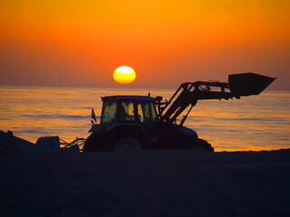 Fototapeta na wymiar A tractor at sunset, symbolizing energy and the sun