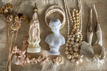 女性の古い白色の彫刻と幾何学のネックレス、鹿の角、珊瑚、皮革を背景にしたアイボリーの標本と植物の集合写真
