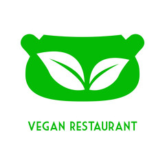 Concepto dieta vegana verde. Logo con texto Vegan Restaurant con silueta de cazuela y hojas de planta en espacio negativo
