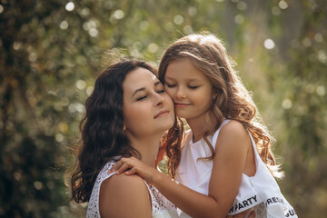 Fototapeta premium Family mother and daughter are beautiful and happy together, in white clothes, in nature