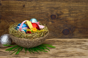 Easter eggs in a nest of hay on wooden table