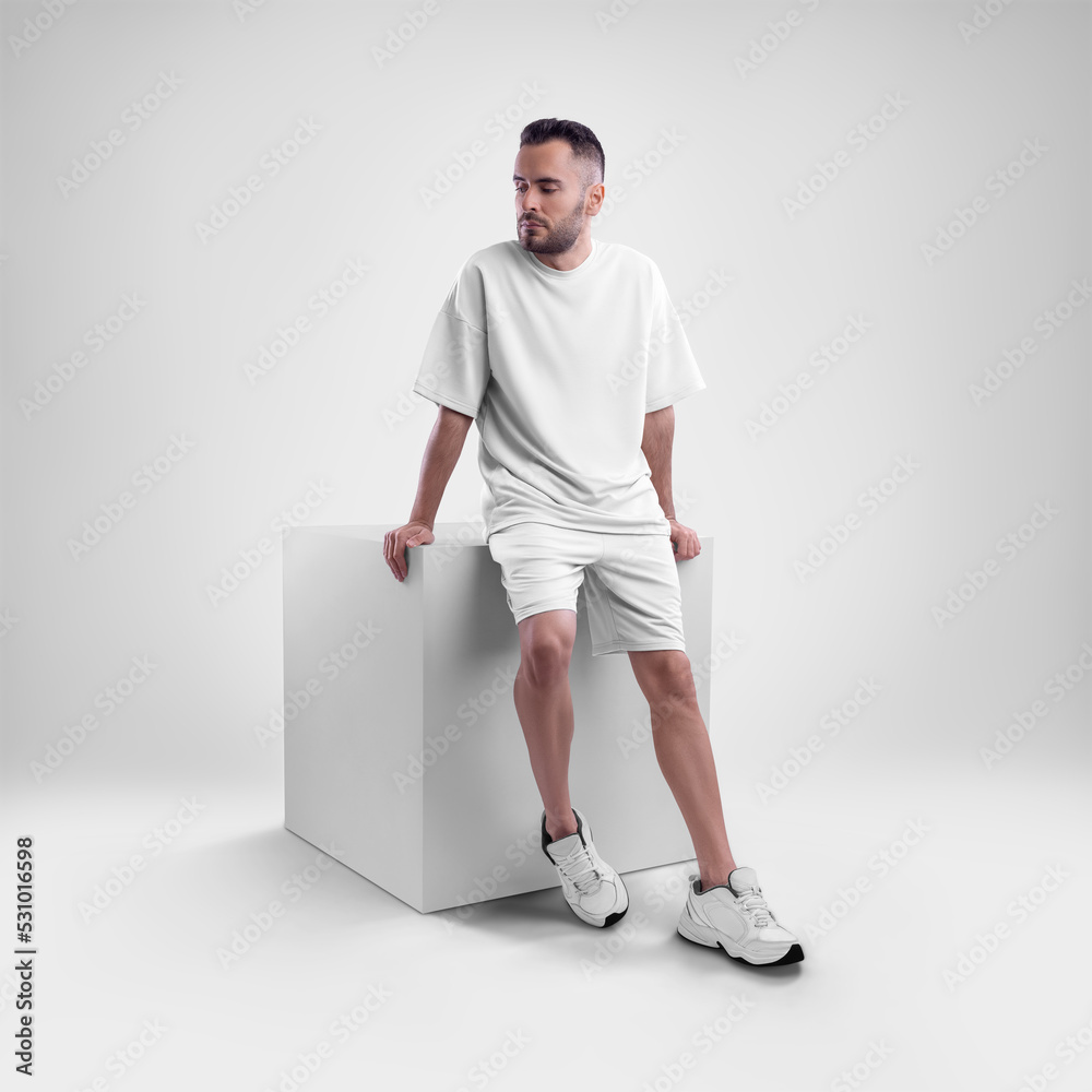 Wall mural Mockup of a white men's oversized t-shirt with shorts on a man on a cube. - Wall murals