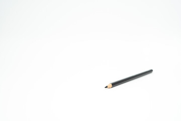 black wooden colored pencil on a white background with a point (lead) in focus