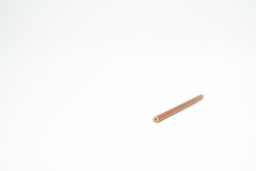 brown wooden colored pencil on a white background with end part in focus