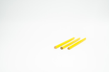 yellow wooden colored pencil on a white background with end part in focus