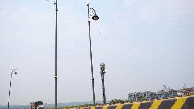 Street lights on side of  road after crossing the Atal setu bridge at Goa in India. Street light as seen from a moving vehicle on the highway. POV of passenger on highway. 
