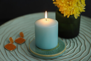 Side table with candle, flowers and earrings in room, closeup