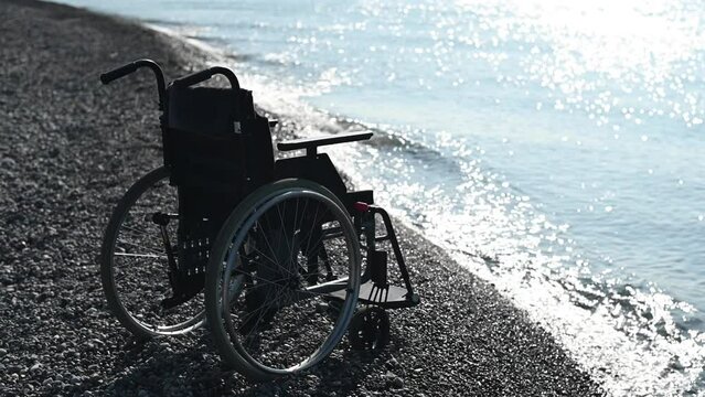 An empty wheelchair on a rocky seashore.