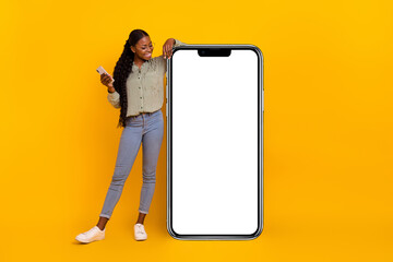 Full body portrait of pretty positive person look empty space huge phone isolated on yellow color...