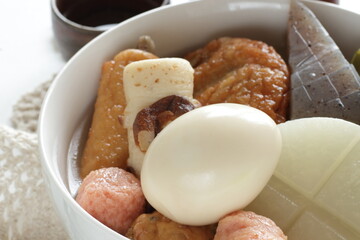 Homemade Japanese winer comfort food, oden fish cake and radish simmered, served with Japanese wine Hot saki