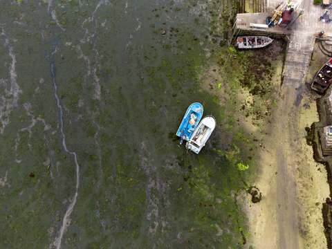 Drone view of Combarro beach with two fishermans's boats stranded on the sand