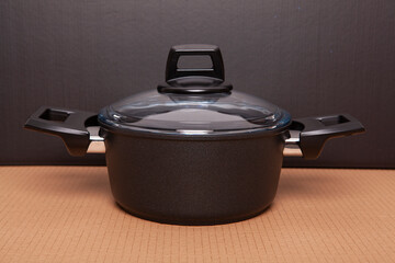 New black granite pot on gray background.