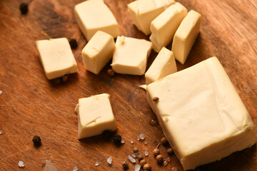 still life of food in a rural style on a dark wood background, sliced cheese, salt and pepper, concept of healthy food