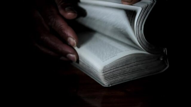 praying to God with hand on bible black background with people stock footage