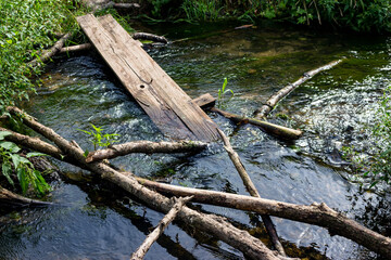 Throwed branches and boards for crossing the stream, a makeshift bridge