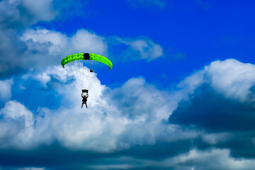 Parachutist against a blue cloudy sky