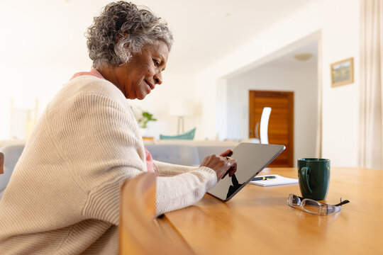 Senior african american women using tablet and drinking coffee