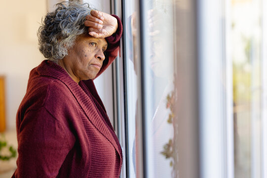 Thoughtful senior african american women looking out the sunny window