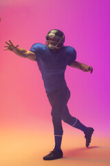 Fototapeta na wymiar Caucasian male american football player wearing helmet with neon pink lighting