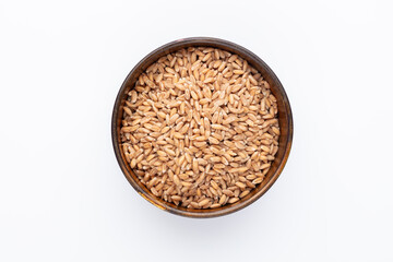 Wheat grains and wooden bowl on white background.