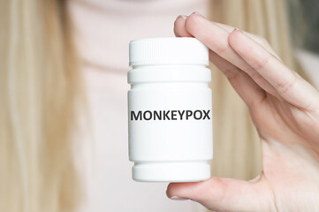 MONKEYPOX inscription on the label of the can in the hand of the doctor's two-piece, medical concept