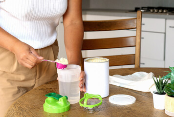 A woman on diet preparing breakfast drink making liquid meal from plant base protein Pea protein...