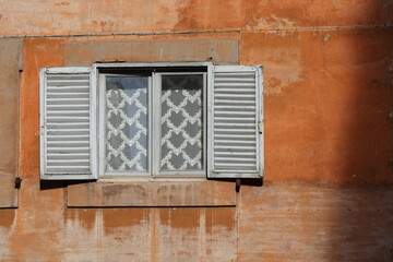 Fototapeta na wymiar Orange Brown Aged House Facade with Window Close Up in Rome, Italy