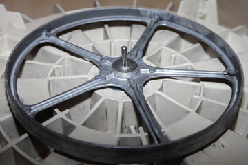 Front load washing machine drive wheel closeup. Washer laundry repair