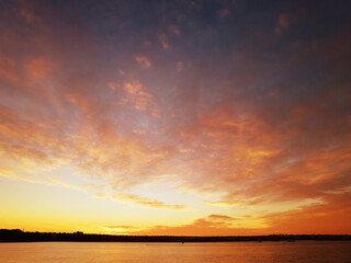 Sunset on the shore of the lake with red clouds