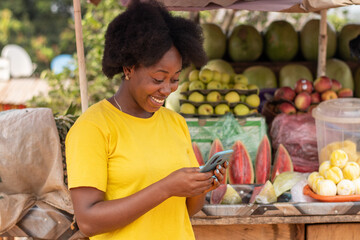 african market woman using her phone to text