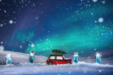 Christmas invitation card background; Christmas tree on toy car with tracks in the snow