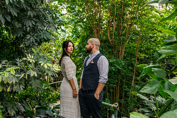 beautiful couple girl and guy in the park among tropical trees