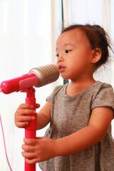 マイクで歌う3歳児