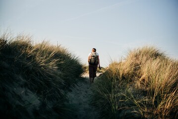 Person hiking a hill under a clear sky